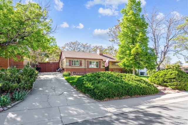 9301 Ciancio St, Thornton, CO 80229 - view of front of home featuring driveway, brick siding, a chimney, and a gate