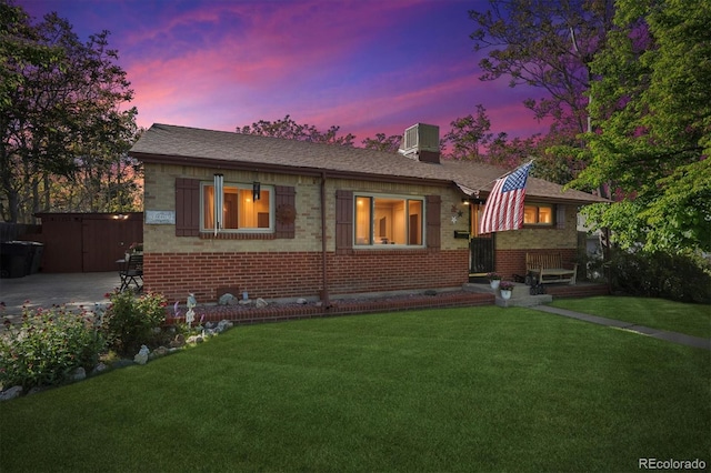 9301 Ciancio St, Thornton, CO 80229 - view of front of house with brick siding, a yard, central air condition unit, and a chimney