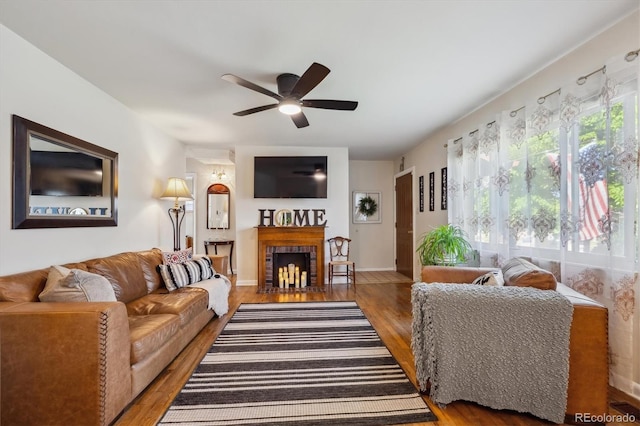 9301 Ciancio St, Thornton, CO 80229 - living area with a ceiling fan, wood finished floors, a brick fireplace, and baseboards