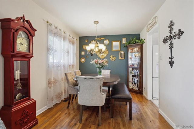 9301 Ciancio St, Thornton, CO 80229 - dining space with a chandelier, wood finished floors, and baseboards
