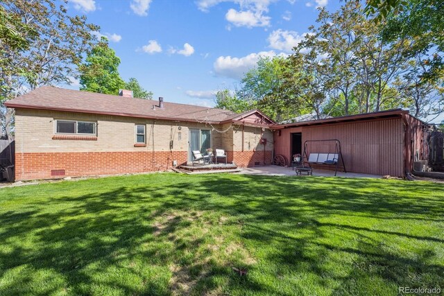 9301 Ciancio St, Thornton, CO 80229 - rear view of house featuring brick siding, a patio area, and a lawn