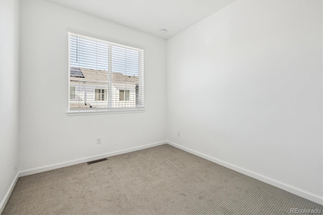 spare room with baseboards, visible vents, and carpet flooring