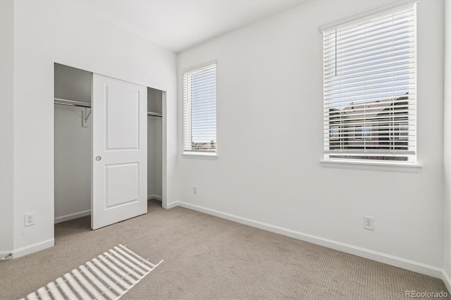 unfurnished bedroom with carpet floors, baseboards, and a closet