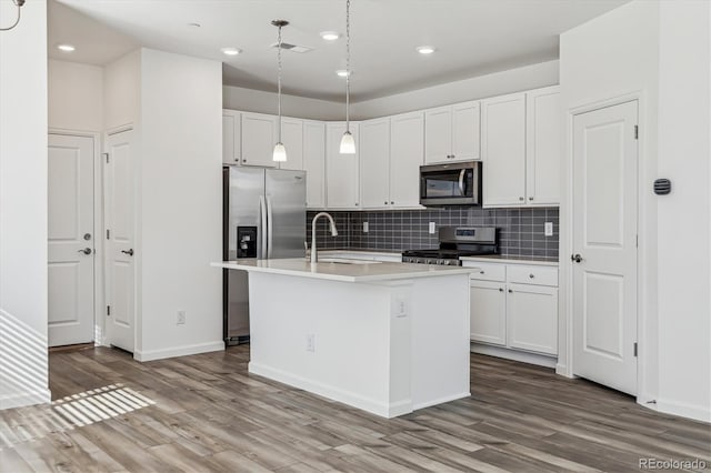 kitchen with appliances with stainless steel finishes, wood finished floors, visible vents, and white cabinets