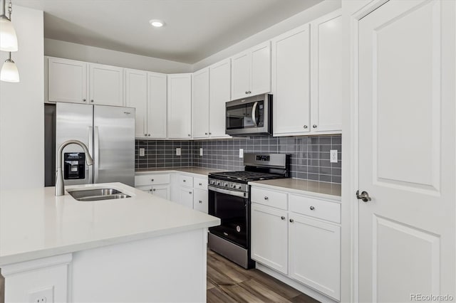 kitchen featuring tasteful backsplash, dark wood finished floors, stainless steel appliances, and light countertops