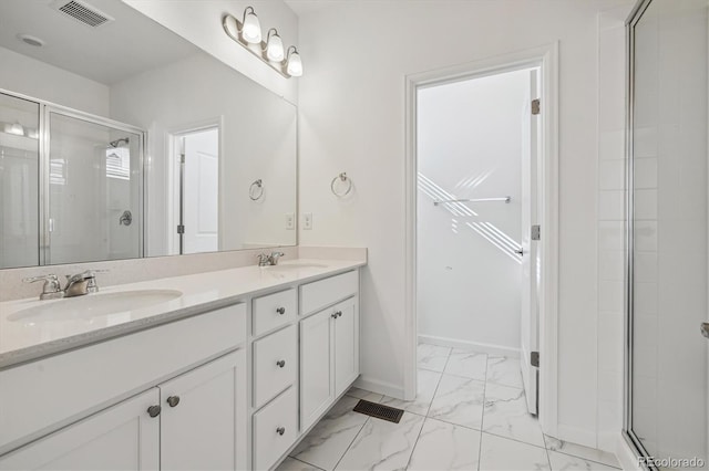 full bath with a stall shower, marble finish floor, visible vents, and a sink