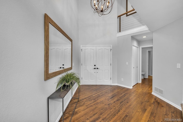 foyer with dark hardwood / wood-style floors and a chandelier