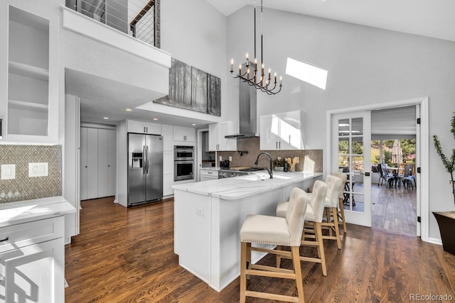 kitchen featuring tasteful backsplash, white cabinetry, appliances with stainless steel finishes, and kitchen peninsula