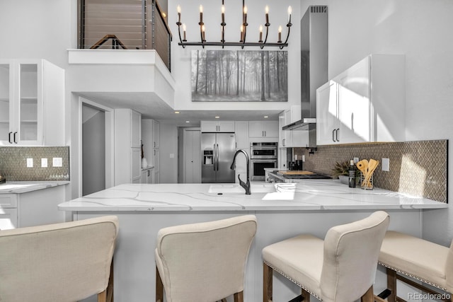 kitchen with white cabinetry, pendant lighting, kitchen peninsula, and appliances with stainless steel finishes