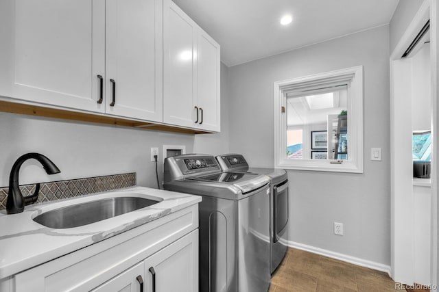 laundry area featuring sink, washer and clothes dryer, and cabinets