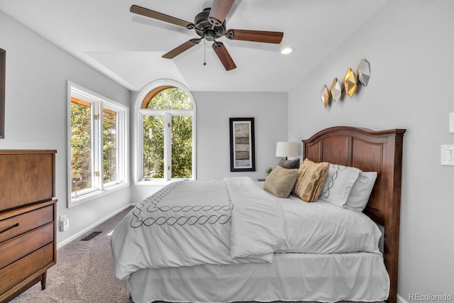 bedroom featuring multiple windows, ceiling fan, lofted ceiling, and light carpet