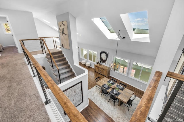 living room with a notable chandelier, high vaulted ceiling, and a skylight