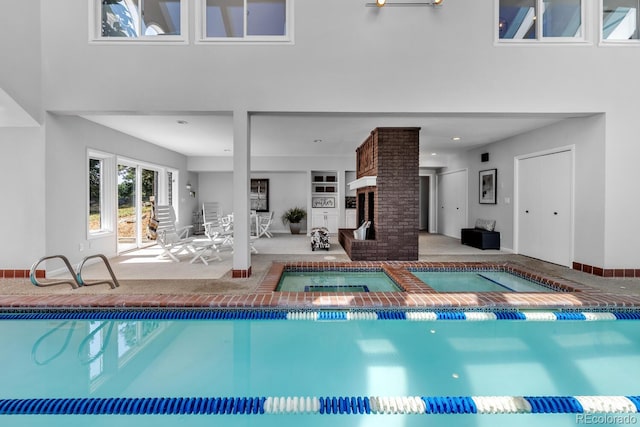 view of swimming pool with a brick fireplace