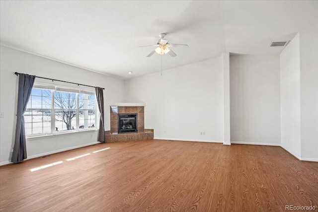 unfurnished living room featuring ceiling fan, a fireplace, and light hardwood / wood-style floors