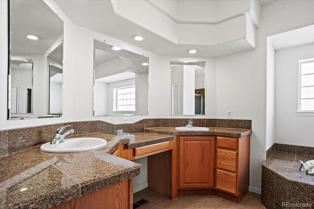 bathroom featuring a tub to relax in, tile patterned floors, plenty of natural light, and vanity