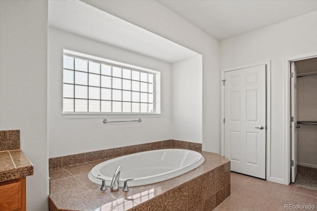 bathroom featuring vanity, tiled tub, and tile patterned floors