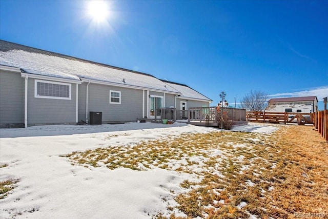 snow covered rear of property featuring a deck