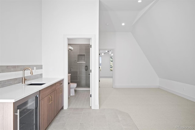 bathroom featuring vanity, wine cooler, vaulted ceiling, tile patterned flooring, and toilet