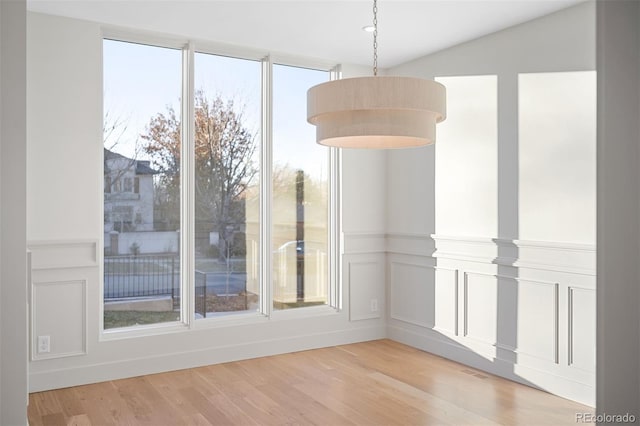 unfurnished dining area featuring wood-type flooring