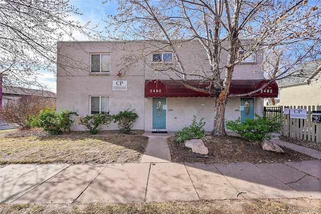 multi unit property with brick siding and fence