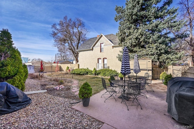 view of patio with area for grilling and fence