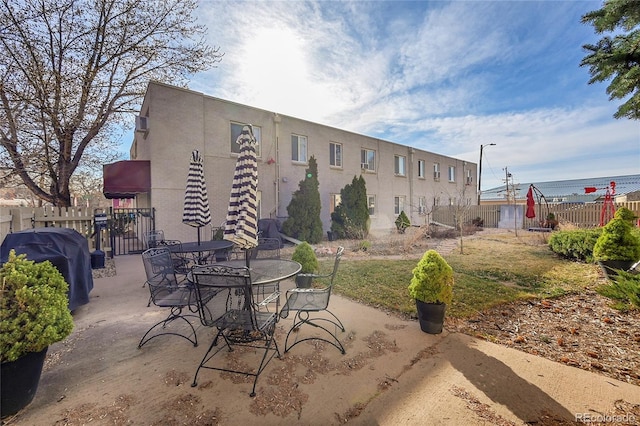 view of patio featuring grilling area, outdoor dining area, and fence