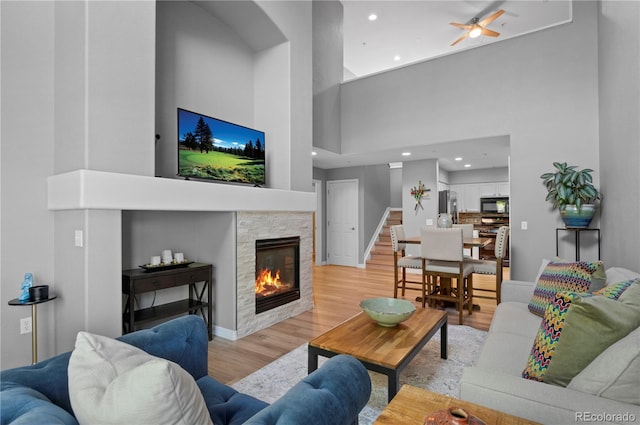 14300 Waterside Ln Unit E3, Broomfield, CO 80023 - living area featuring a towering ceiling, light wood finished floors, a stone fireplace, a ceiling fan, and recessed lighting