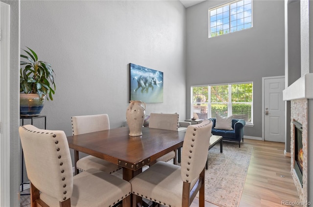 14300 Waterside Ln Unit E3, Broomfield, CO 80023 - dining space featuring a high ceiling, light wood finished floors, and a glass covered fireplace