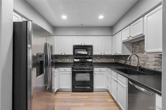 14300 Waterside Ln Unit E3, Broomfield, CO 80023 - kitchen featuring black appliances, dark countertops, light wood-style floors, white cabinets, and recessed lighting