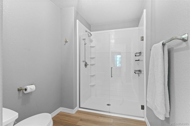 14300 Waterside Ln Unit E3, Broomfield, CO 80023 - bathroom featuring wood finished floors, a shower stall, and a textured wall