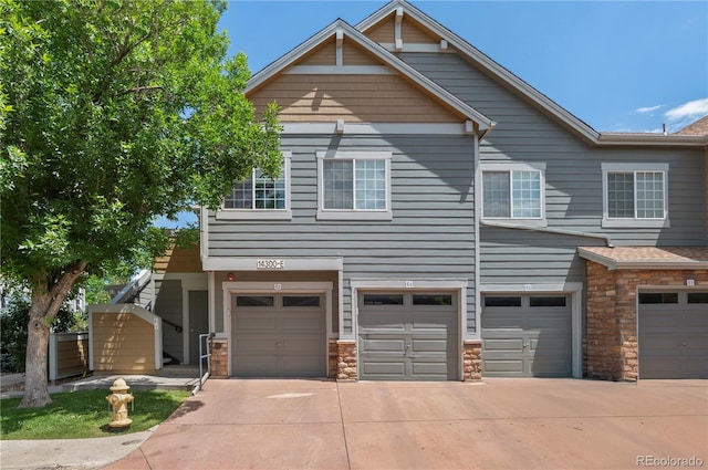 14300 Waterside Ln Unit E3, Broomfield, CO 80023 - view of front facade featuring a garage, stone siding, and driveway