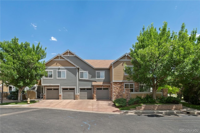 14300 Waterside Ln Unit E3, Broomfield, CO 80023 - view of front of home featuring an attached garage, driveway, and stone siding