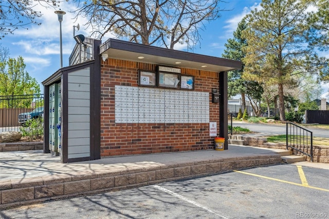 view of community featuring uncovered parking and mail area