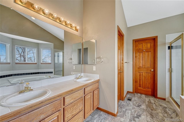 bathroom featuring lofted ceiling, a shower stall, and a sink