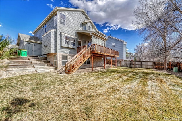 rear view of property featuring stairs, fence, a lawn, and a wooden deck