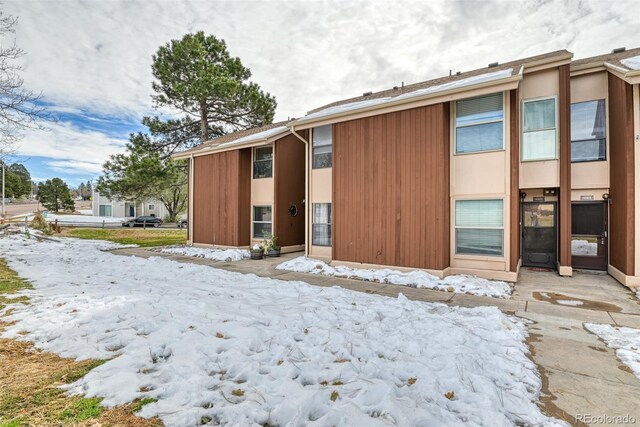 view of snow covered rear of property