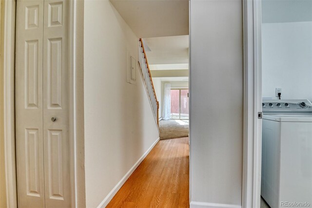 corridor with washer / clothes dryer and light hardwood / wood-style floors