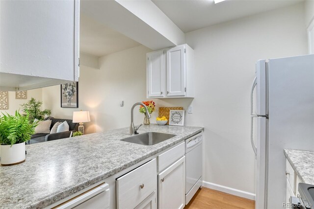 kitchen with sink, white cabinets, white appliances, and light wood-type flooring