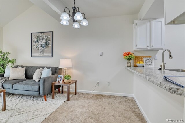 interior space with a chandelier, vaulted ceiling, and sink