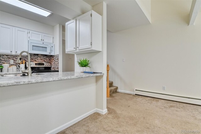 kitchen featuring light carpet, tasteful backsplash, light stone counters, sink, and white cabinets