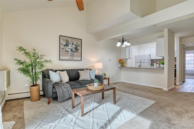 living room featuring ceiling fan with notable chandelier, light colored carpet, and high vaulted ceiling