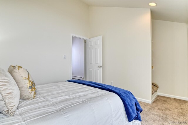 bedroom featuring light colored carpet, baseboard heating, and high vaulted ceiling