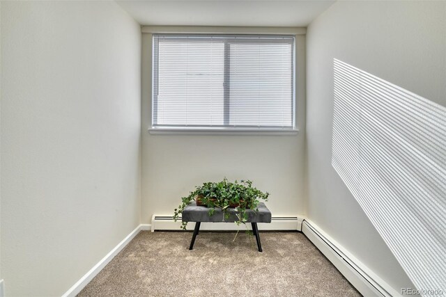 sitting room with a baseboard radiator and light colored carpet