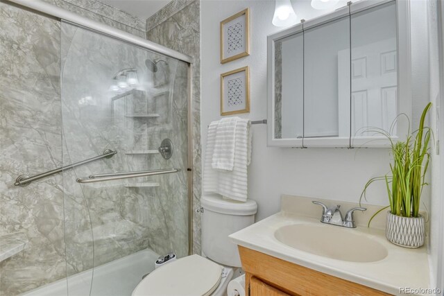 bathroom featuring vanity, toilet, and an enclosed shower