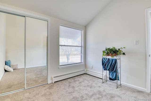 unfurnished bedroom with light carpet, a baseboard radiator, and vaulted ceiling