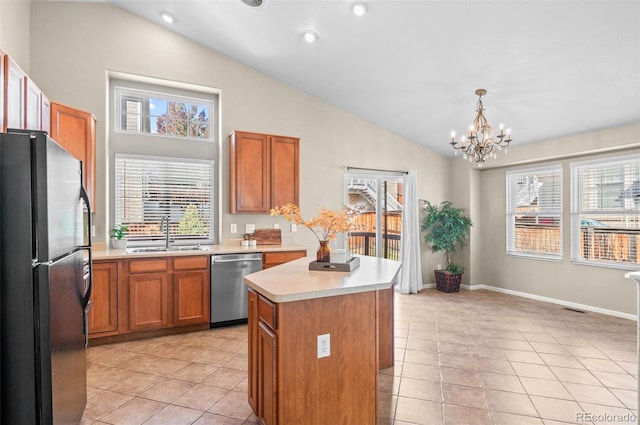 kitchen featuring dishwasher, lofted ceiling, black refrigerator, sink, and a kitchen island