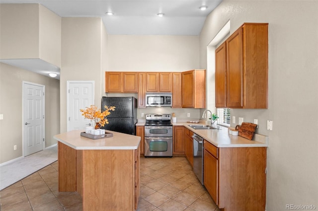 kitchen featuring a kitchen island, sink, light tile patterned floors, and stainless steel appliances