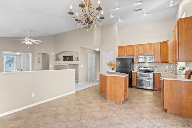 kitchen featuring appliances with stainless steel finishes, sink, light tile patterned floors, pendant lighting, and a kitchen island