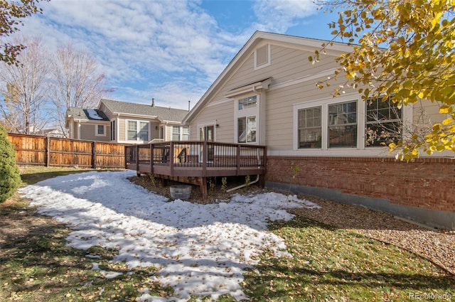 snow covered rear of property featuring a wooden deck