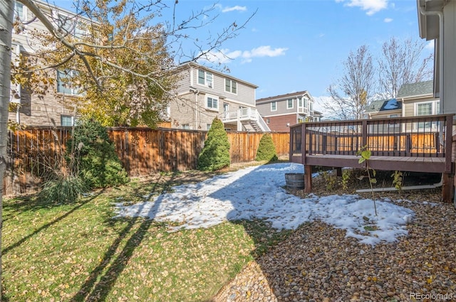 yard covered in snow with a deck